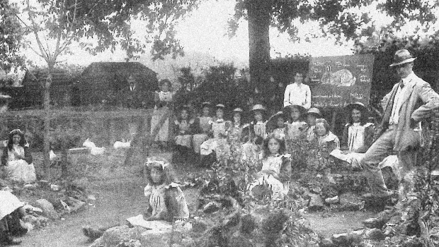 Black and white image of children in outdoor school lesson